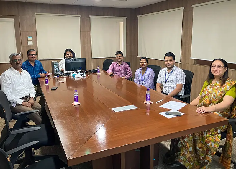 Seven people sit at a board room table.